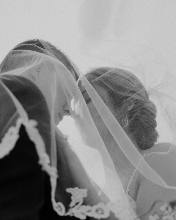 black and white po of bride kissing groom