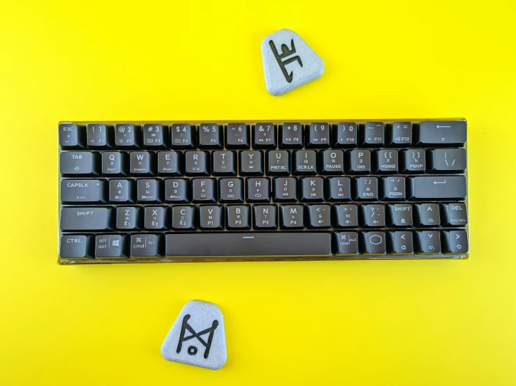 two rocks sit on top of the keyboard with the letter y painted on them