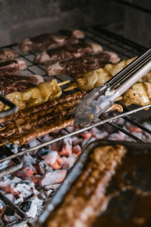 food being grilled and seasoned over an open grill