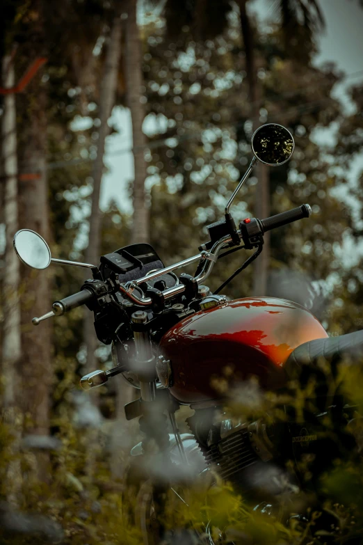 an old fashioned motorcycle parked outside next to a forest