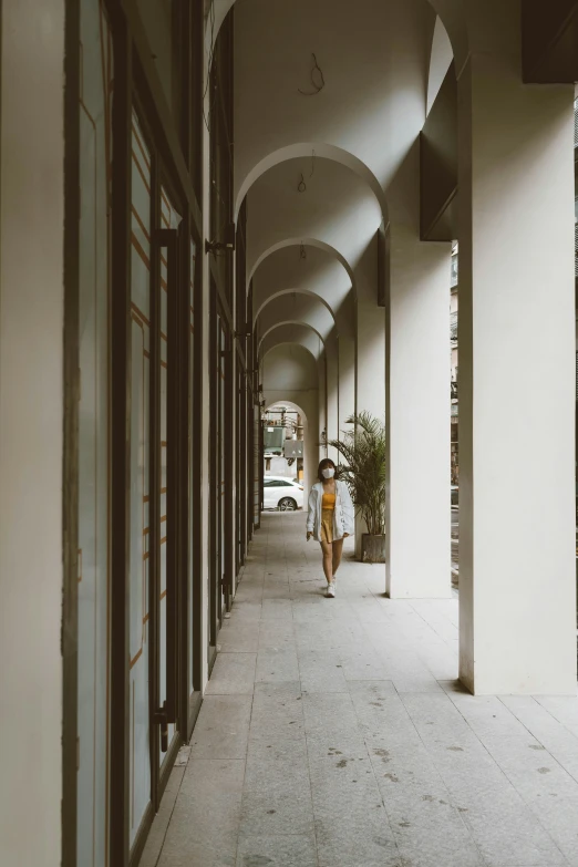 an old po of some buildings and the person walking in the corridor