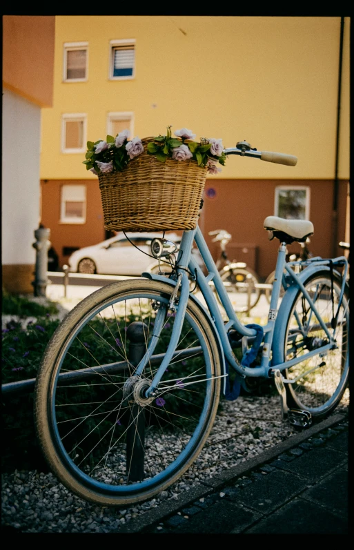 a blue bike with a basket on it parked in front of a house