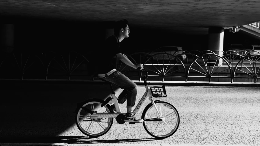 the man is riding his bicycle in black and white