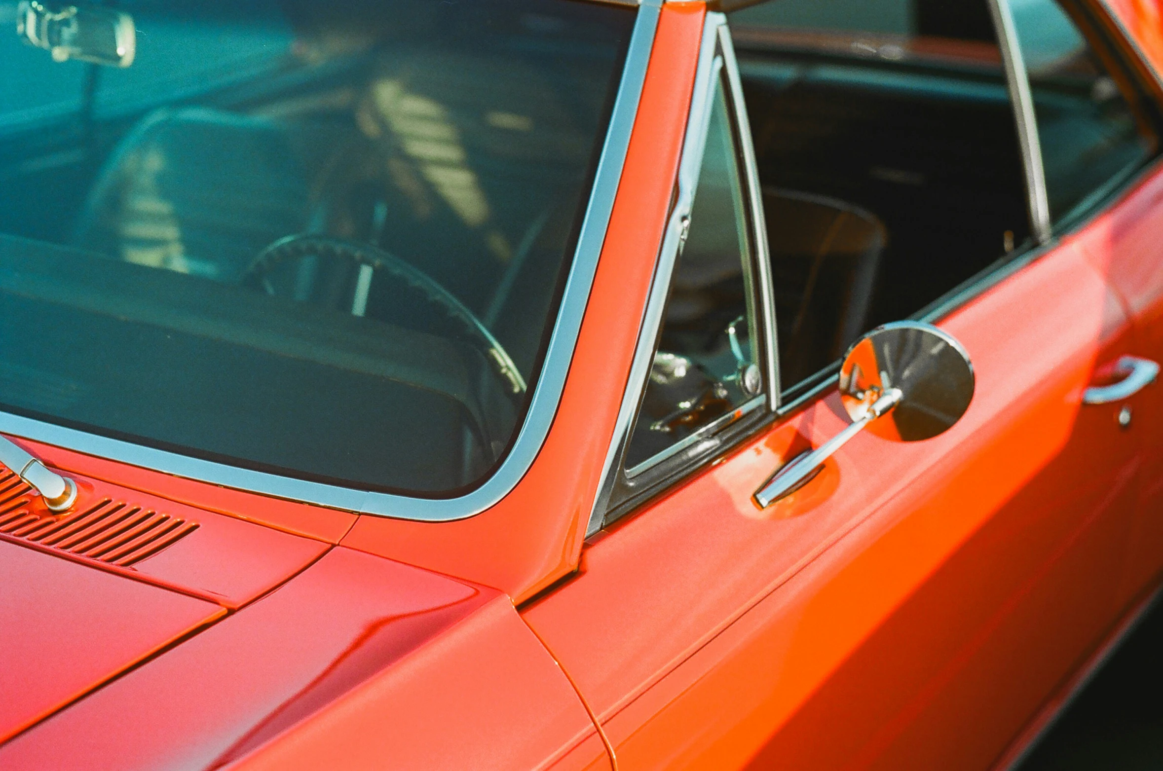 a red car with an orange rear view mirror