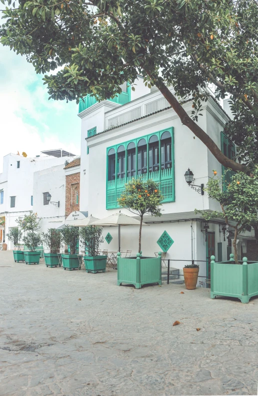 two green chairs are outside of a white building