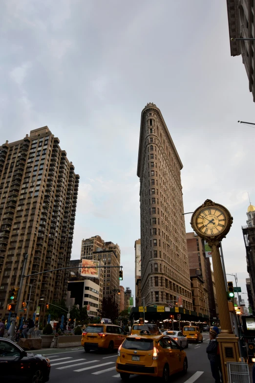 city street with large clock and other tall buildings