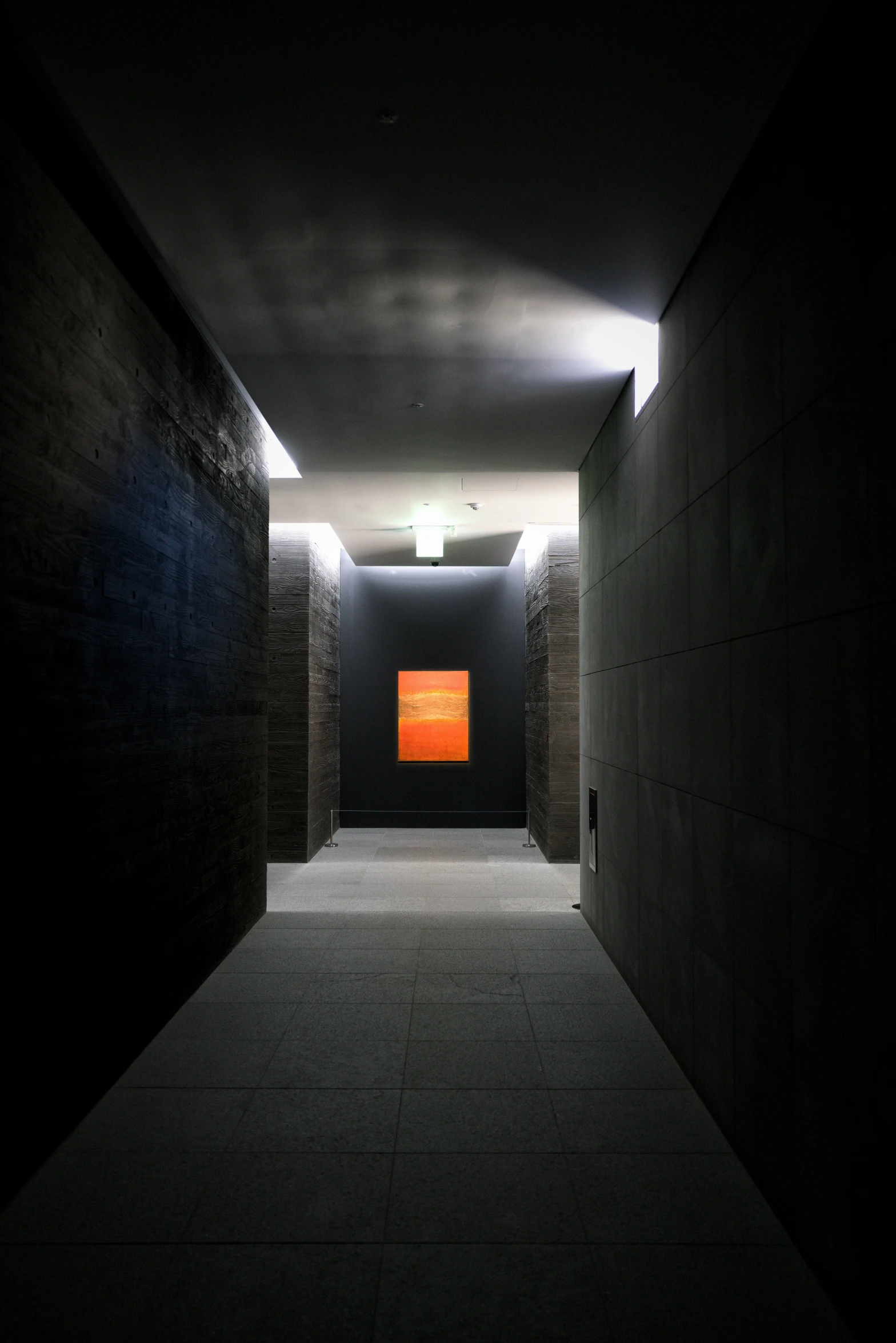 a hallway that has an orange sign in it