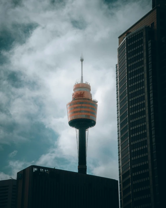 a water tower with a clock on top against some clouds