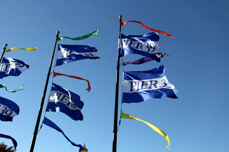 a bunch of different flags flying in the air