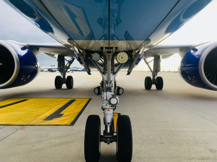 the rear wheels of a airplane parked on a runway