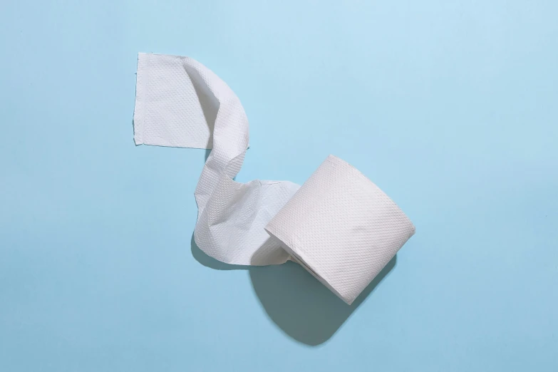 an unbleved roll of toilet paper on a light blue background