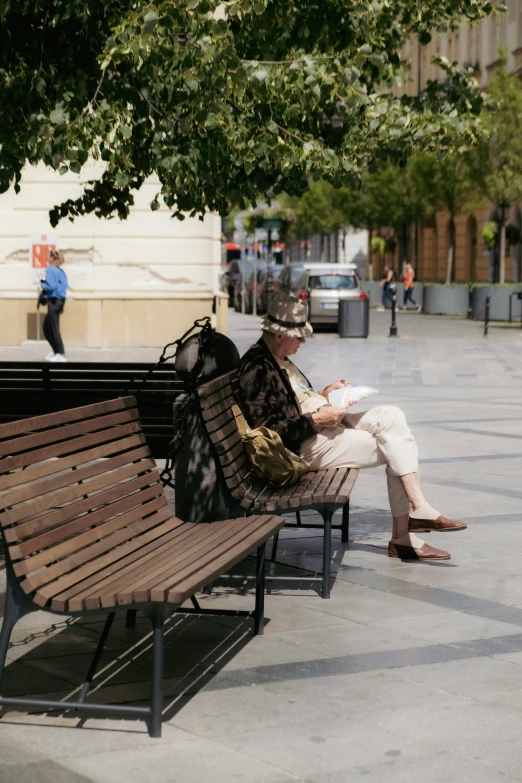 an older gentleman is sitting on a park bench