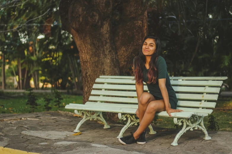 a woman sitting on a bench in the sun