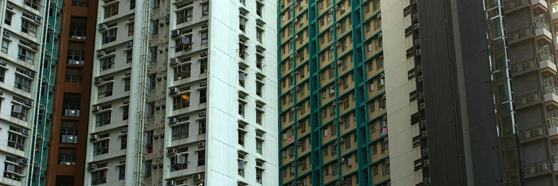 a group of buildings in hong kong, with green colored shutters on each window