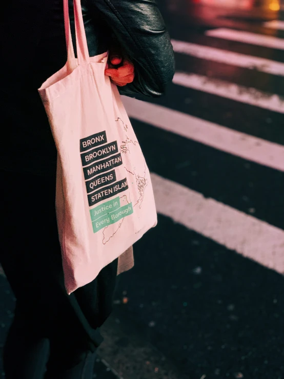 a person carrying a pink bag on a street