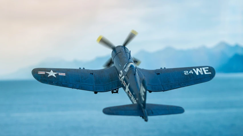 a military airplane flying over a large body of water