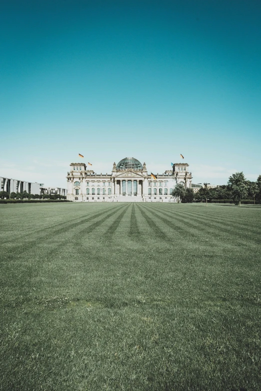 a tall white building in the middle of grass