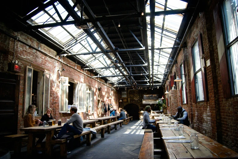 several people eating in an open - air covered room