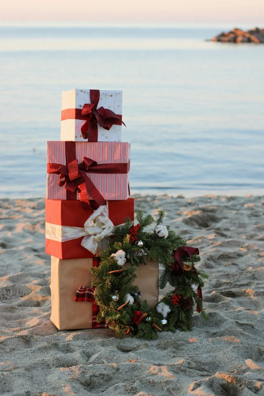 a couple of gift bags are stacked up on a beach