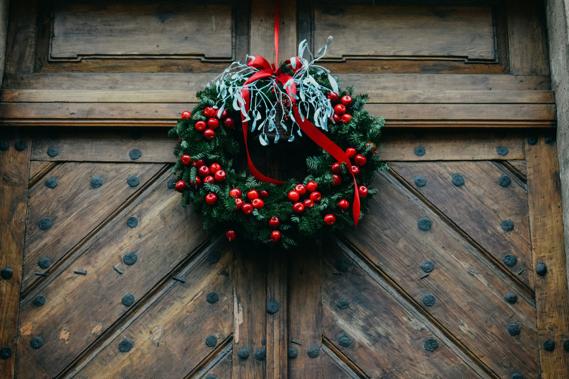 a decorative christmas wreath on an old door