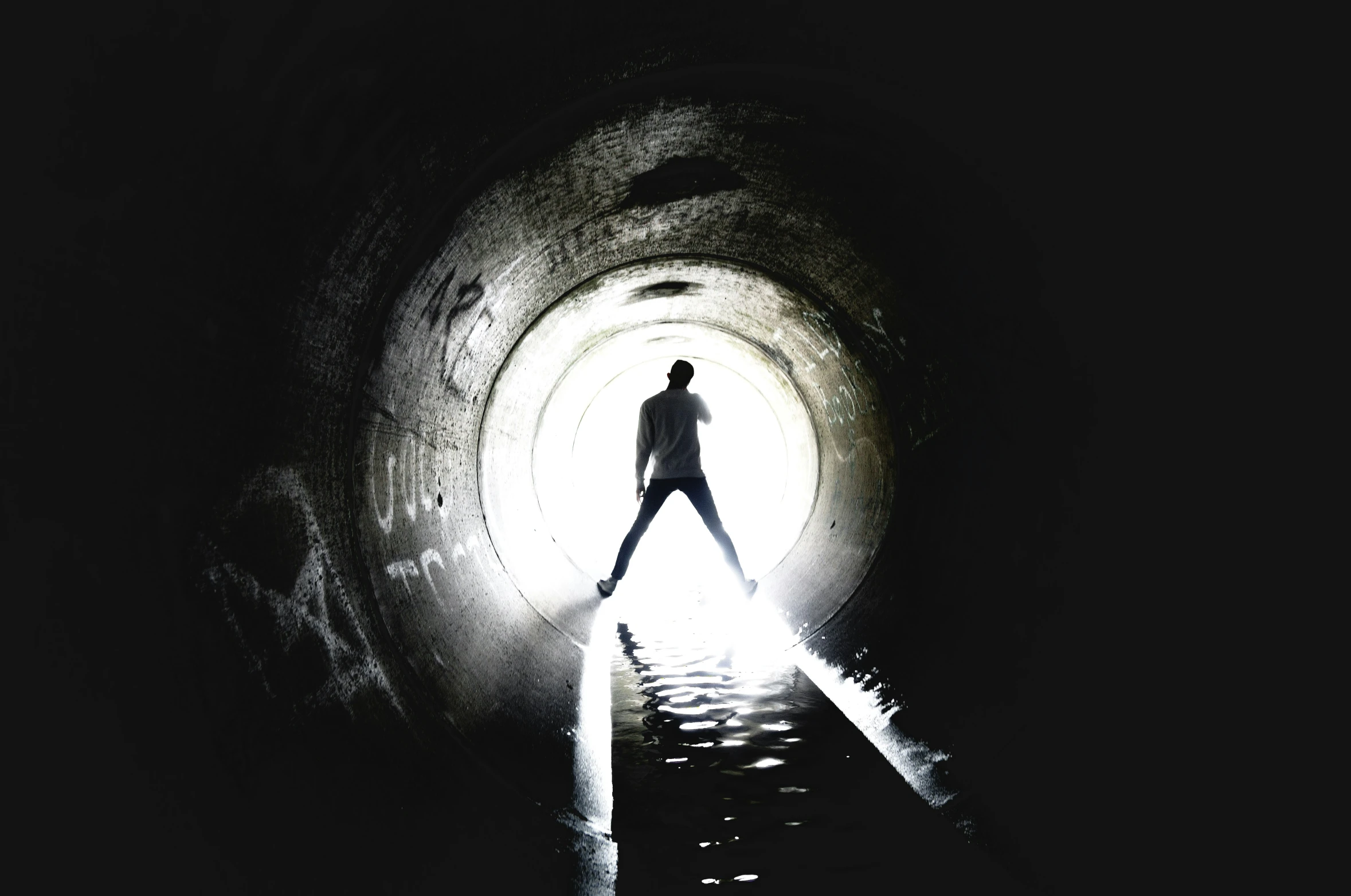 a man in a dark tunnel with his leg up