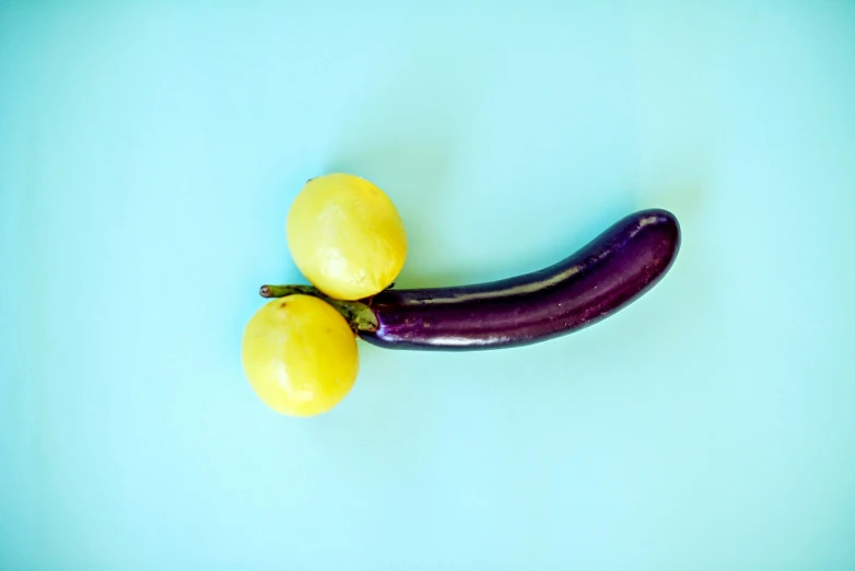 the purple eggplant has two large yellow bananas