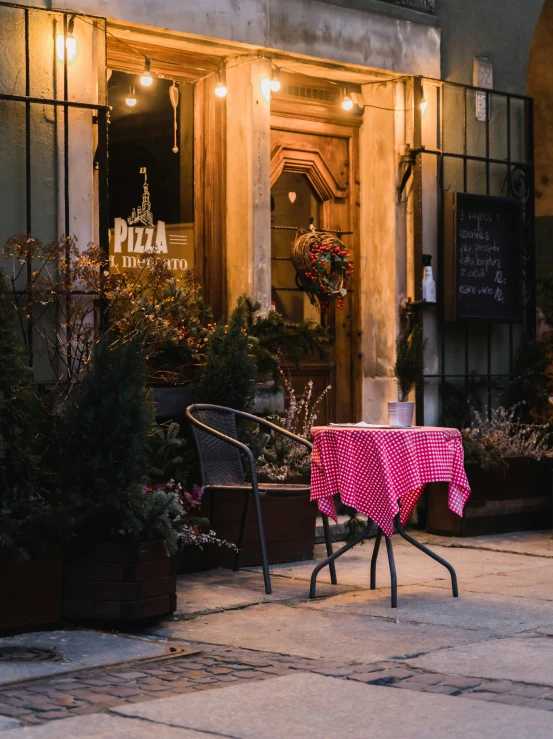 some chairs sitting outside a large building with lights on