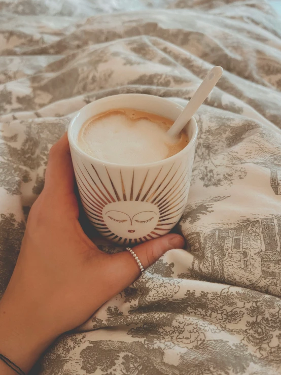 a cup of coffee sits in someone's hand with a straw in it