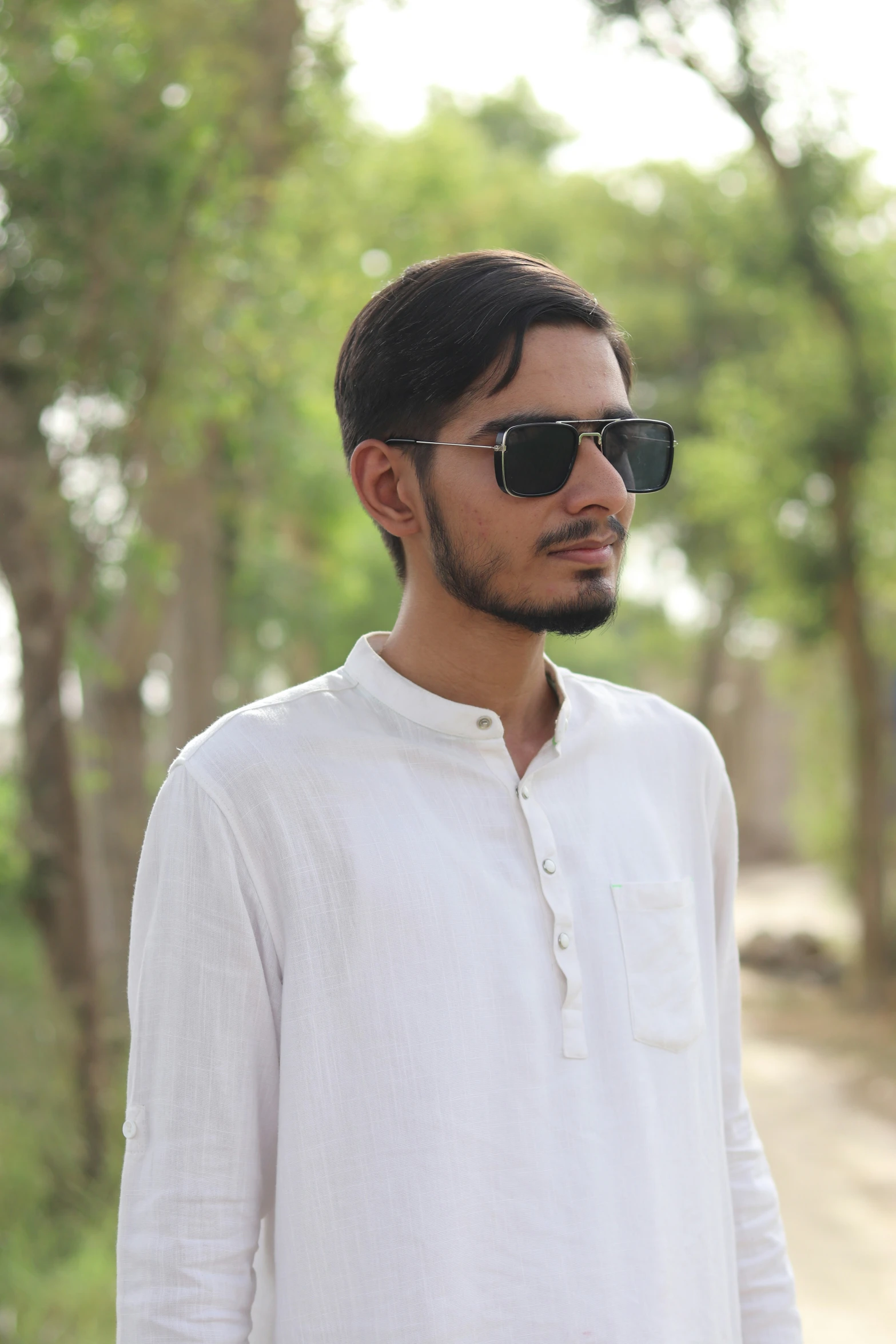 a man is standing by the road wearing sunglasses