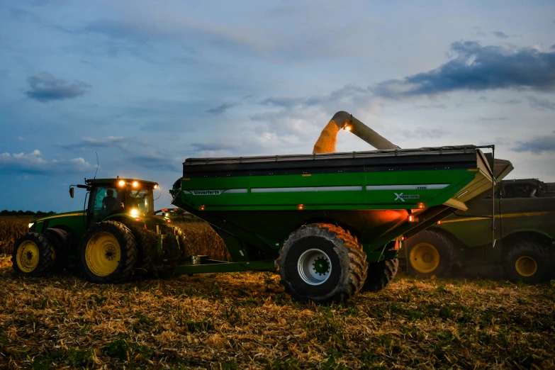 a large tractor and a combineer are in a field