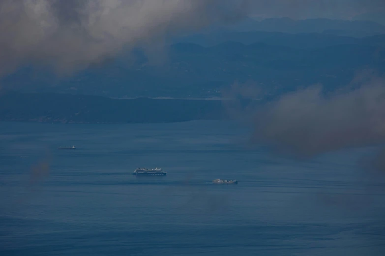 two small ships traveling in a wide open body of water