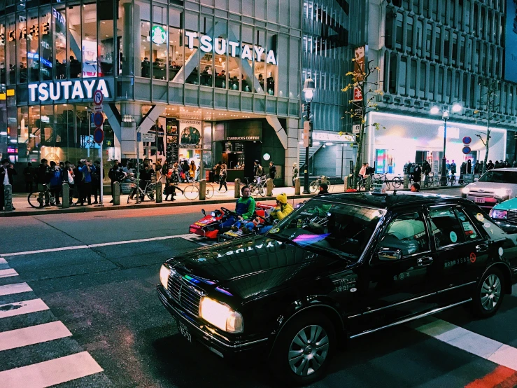 a very cute car on the street in front of a big building