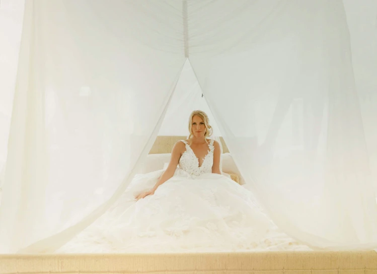 bride sitting in bed with white sheer ds