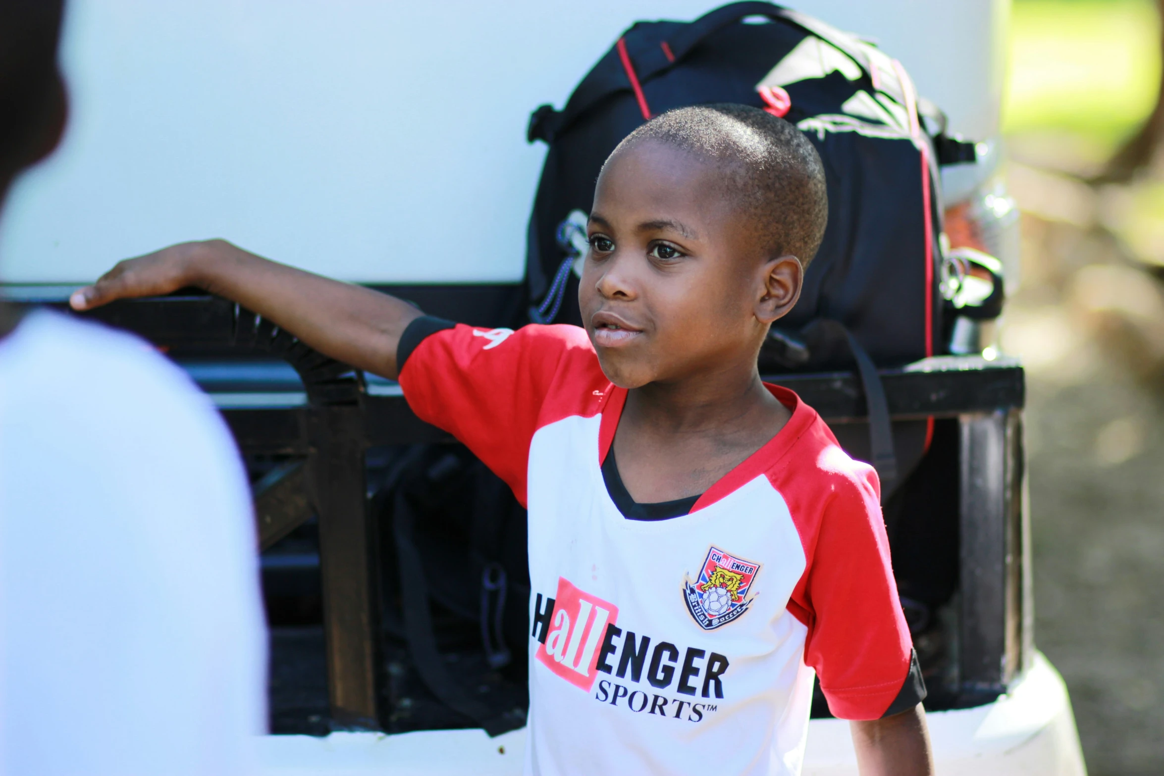 a young child in red and white holding his hand out for someone