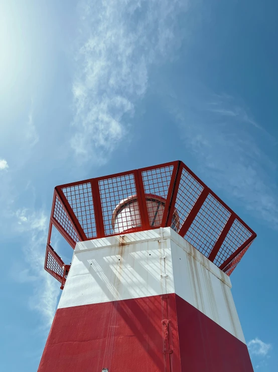 the tall clock is next to a red and white tower