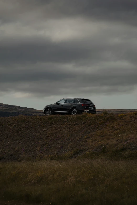 a black four - door suv is on the side of a hill