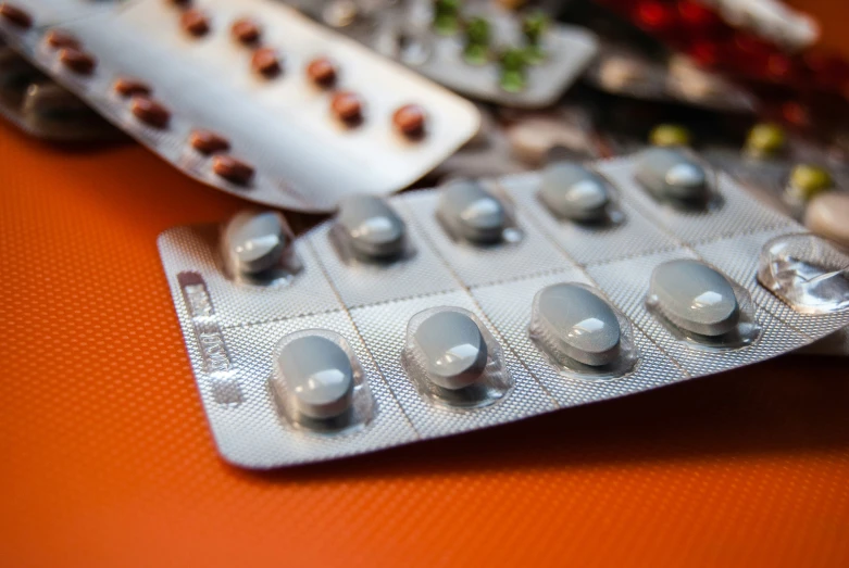 a group of pills on an orange table