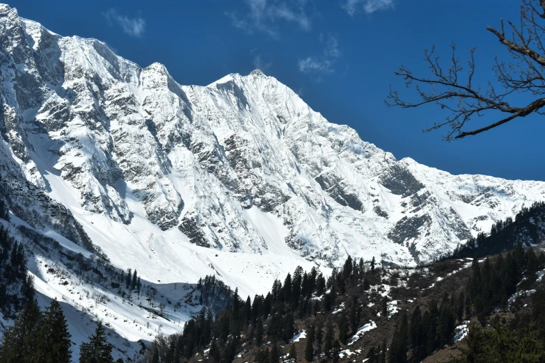 a snow covered mountain is under a blue sky