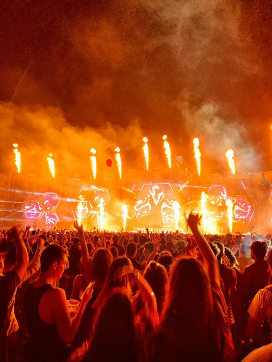 fireworks and lights shine as crowd of people stand around watching