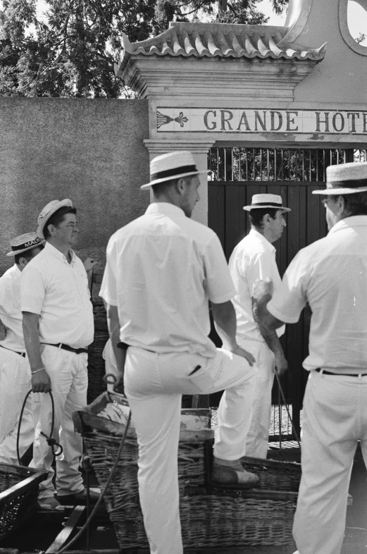 several men in white are standing outside of a el