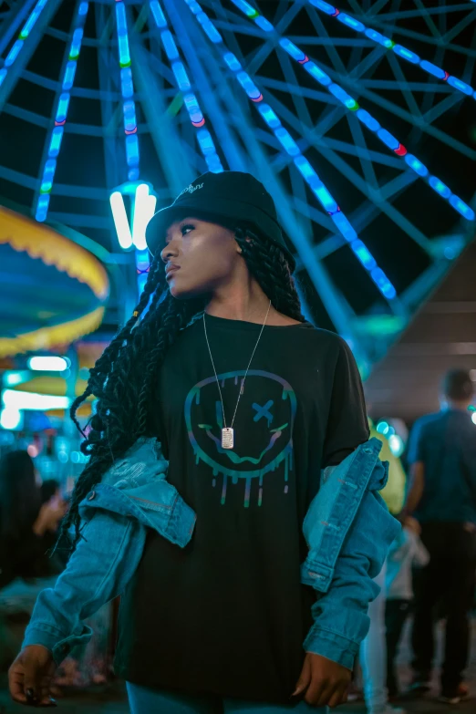 a young man in a black t - shirt under a fair goer's ferris wheel