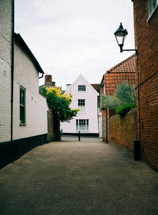 a street lined with white brick buildings next to two red brick houses