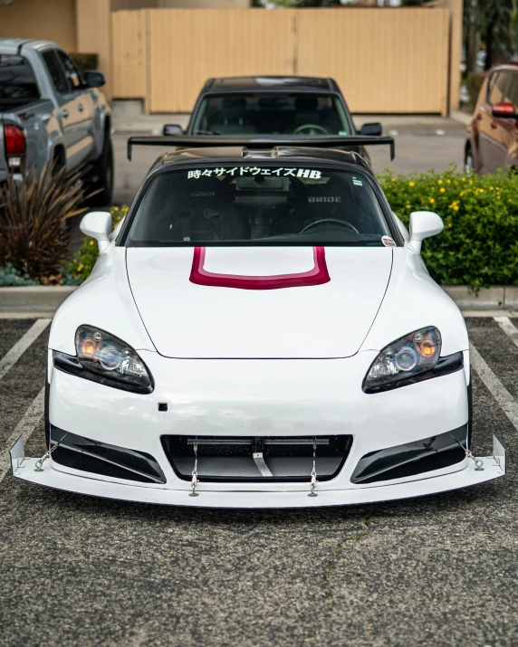 a white sports car is parked in a parking lot