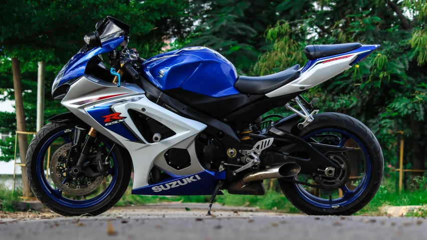 a motorcycle parked on the side of a street next to trees