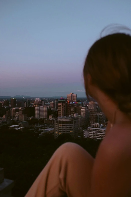 view over the city and the skyline from above a women's head in the foreground