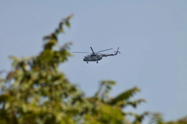 a helicopter flying above a tree filled forest