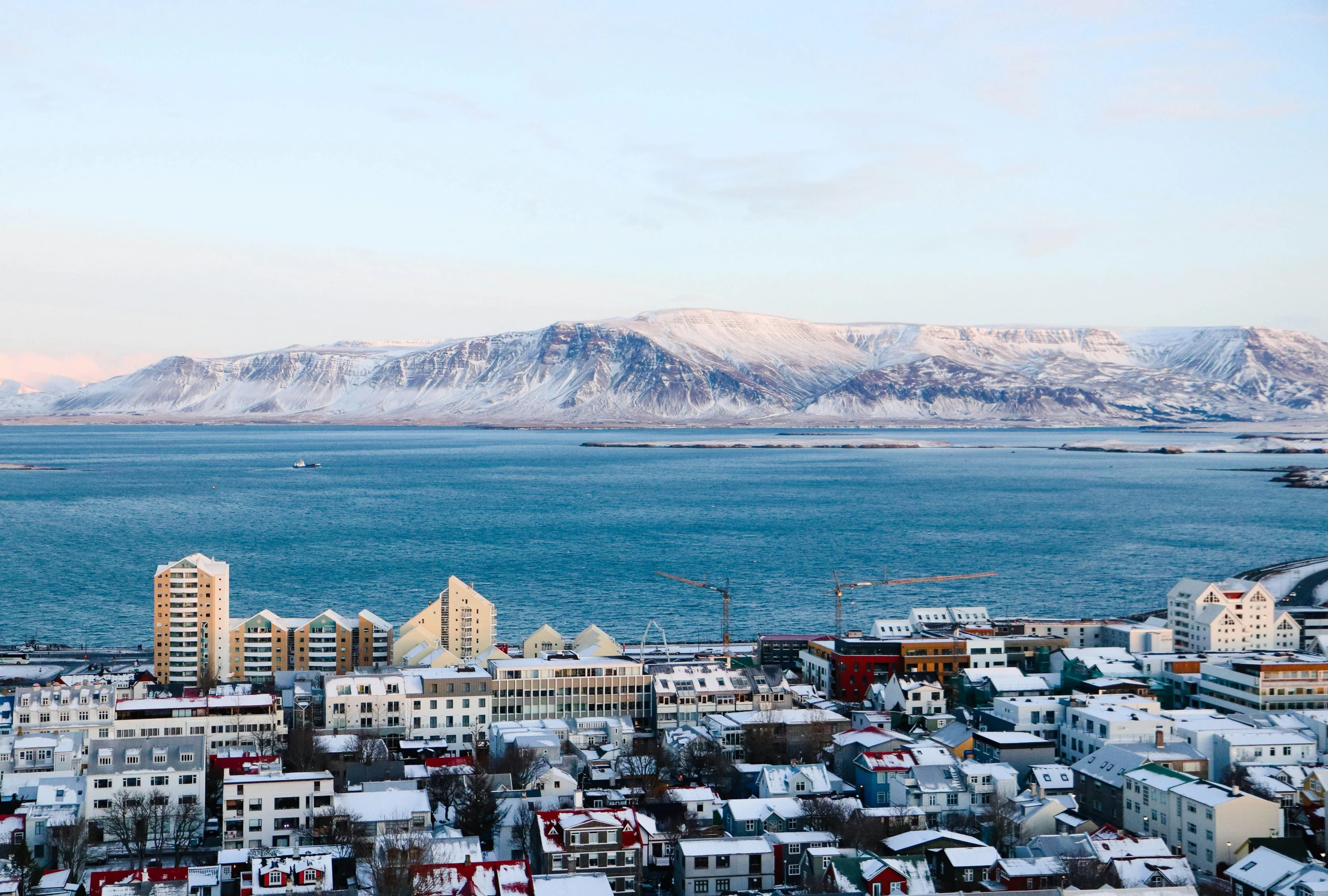 view of the city and surrounding mountains with snow