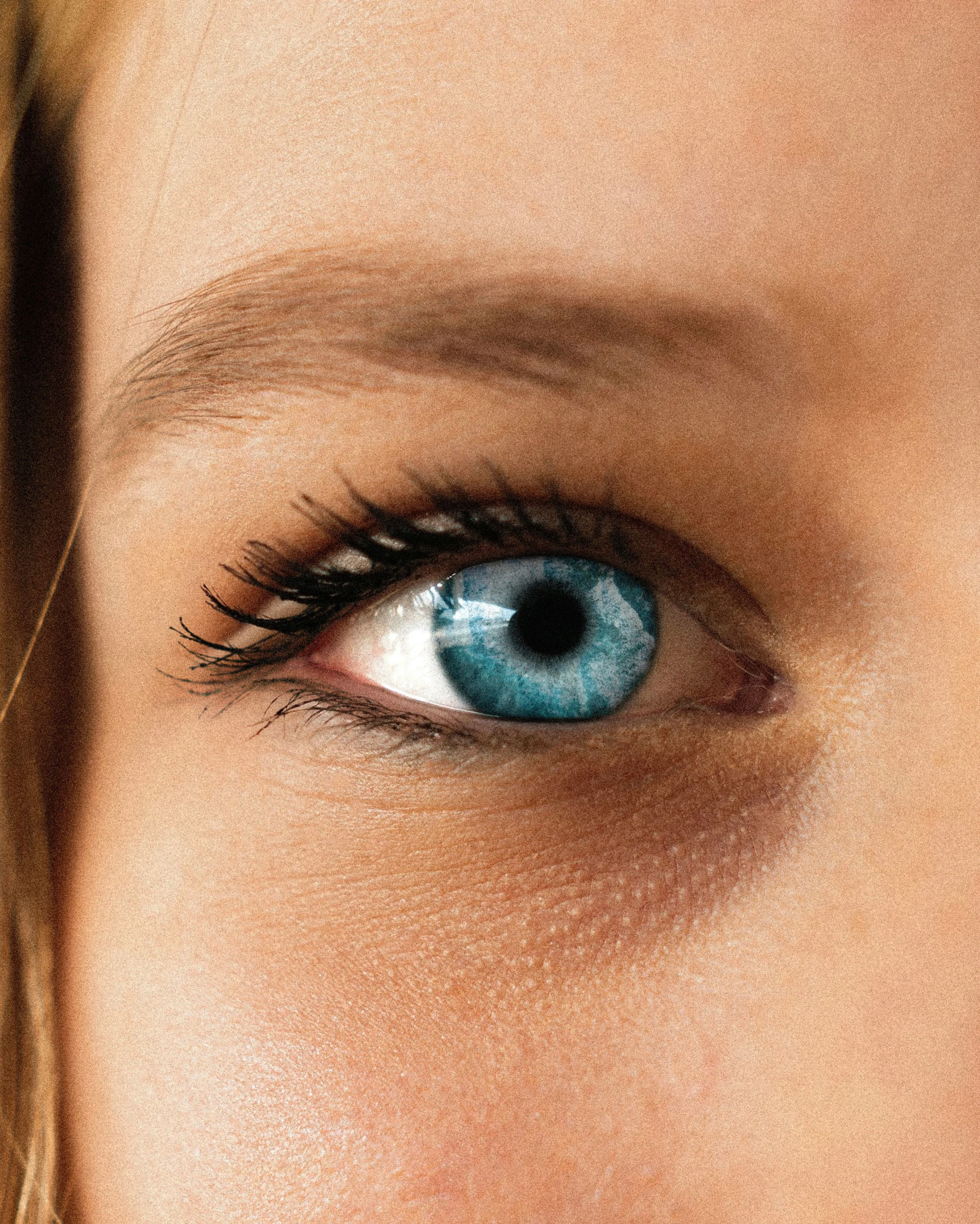 woman with large blue eye looking up at camera