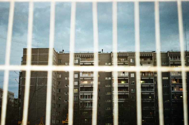 looking through bars at a tall building with windows