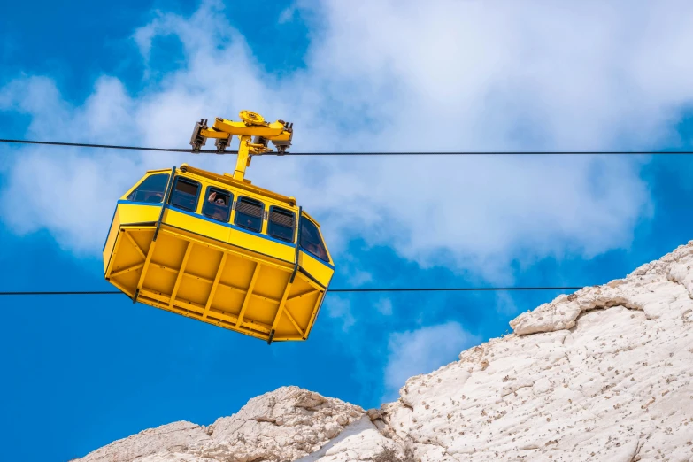 a yellow ski lift lifting people down onto a mountain